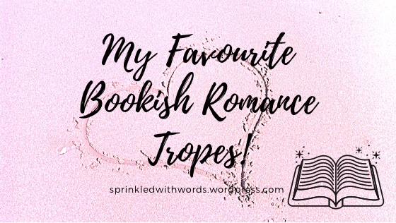 Title in script:  "my favourite bookish romance tropes" on top of a pink background with a heart drawn in sand  